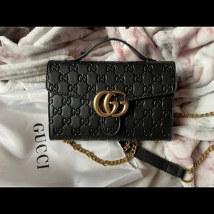 Black Gucci shoulder bag with gold chain.